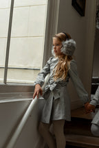 Girl wearing the Elle Blouse in Dove with matching skirt on the Canal House stairs