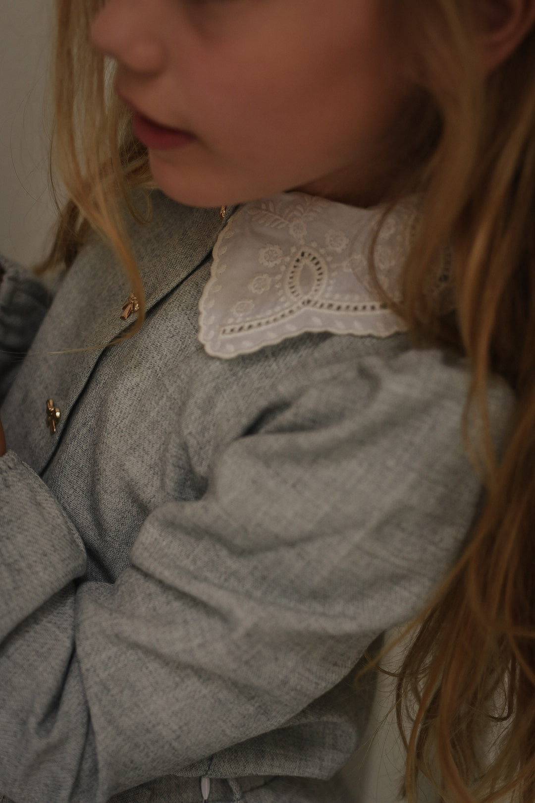 Close-up of the Elle Set in Dove showing the embroidered white collar and gold bow buttons