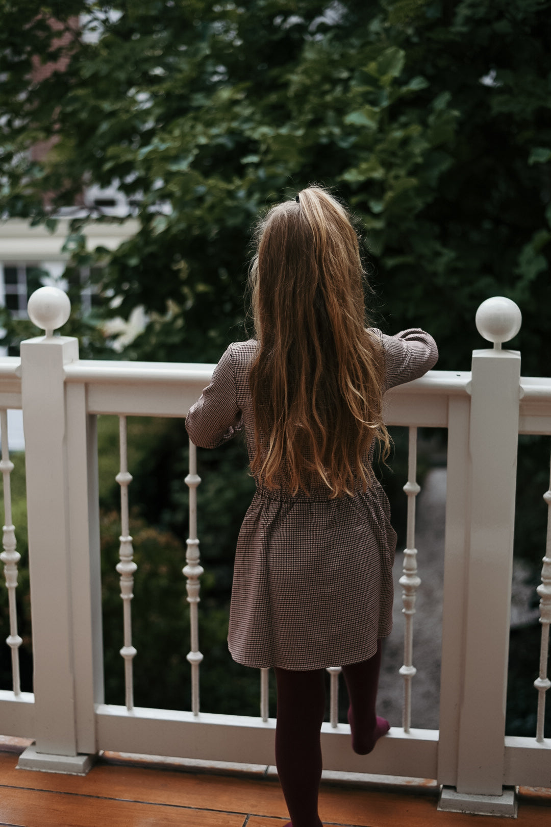 Back view of the Isabella Dress in Houndstooth on the Canal House balcony