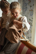 Girl wearing the Zara Blouse in sand with a teddy backpack in the Canal House