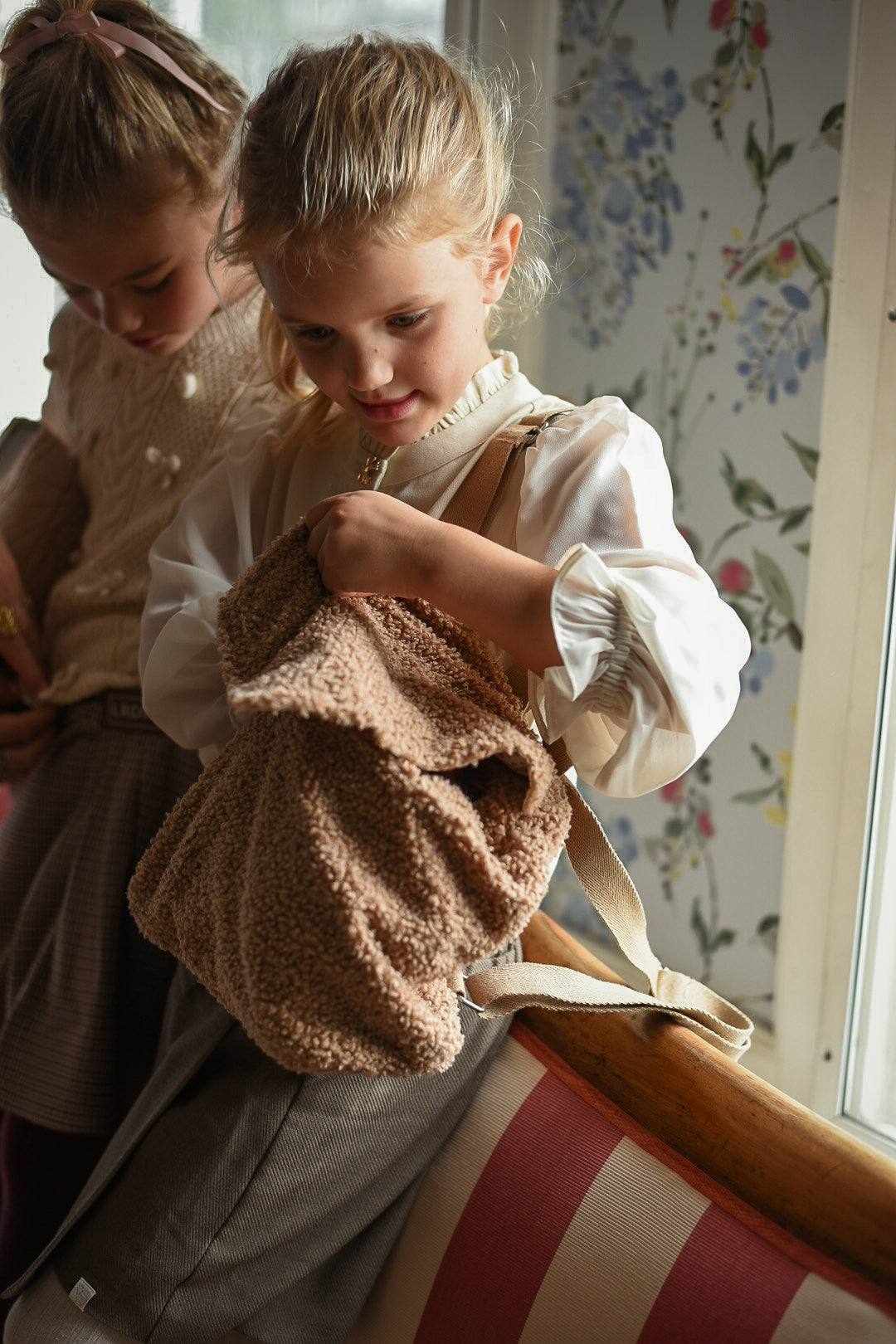 Girl wearing the Zara Blouse in sand with a teddy backpack in the Canal House