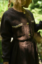 Close-up of the chocolate Charlie Knit cardigan and matching skirt in woodland light