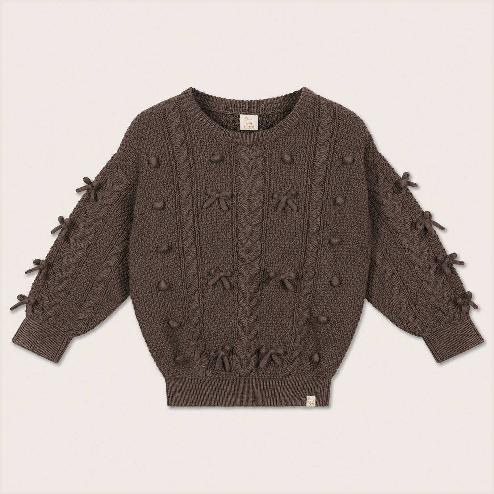 Elise Bow Pull in Chocolate with cable-knit bow details on a neutral background