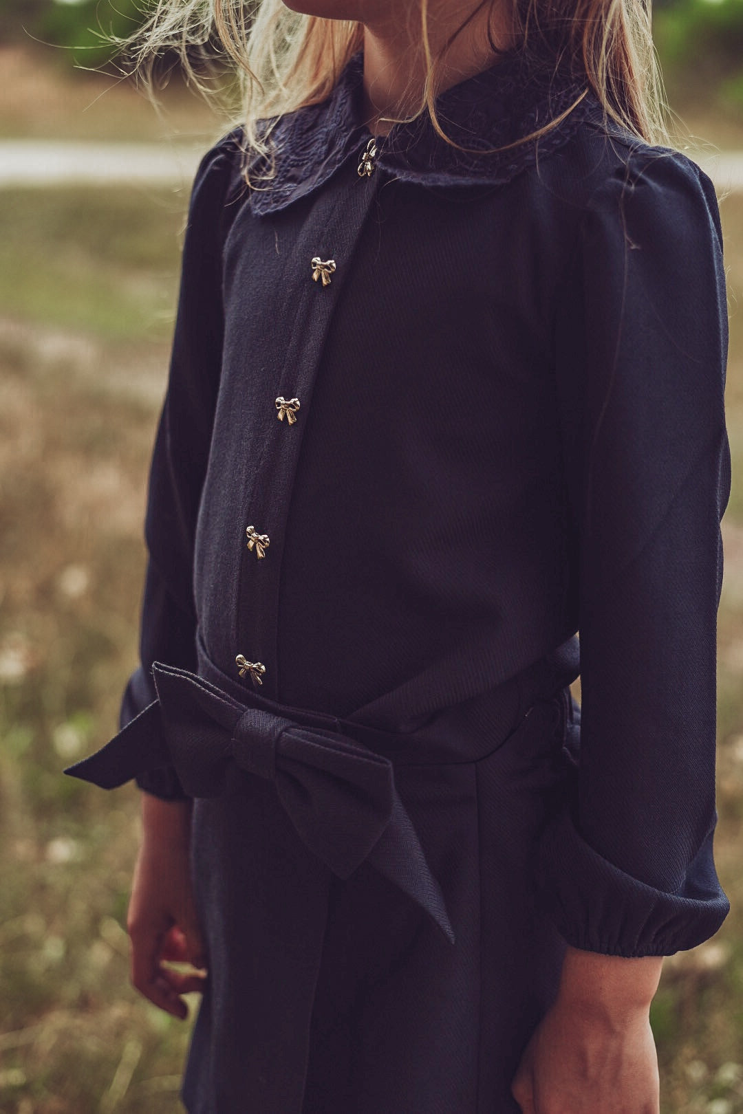 Close-up of the navy Elle Blouse and matching skirt on the heath