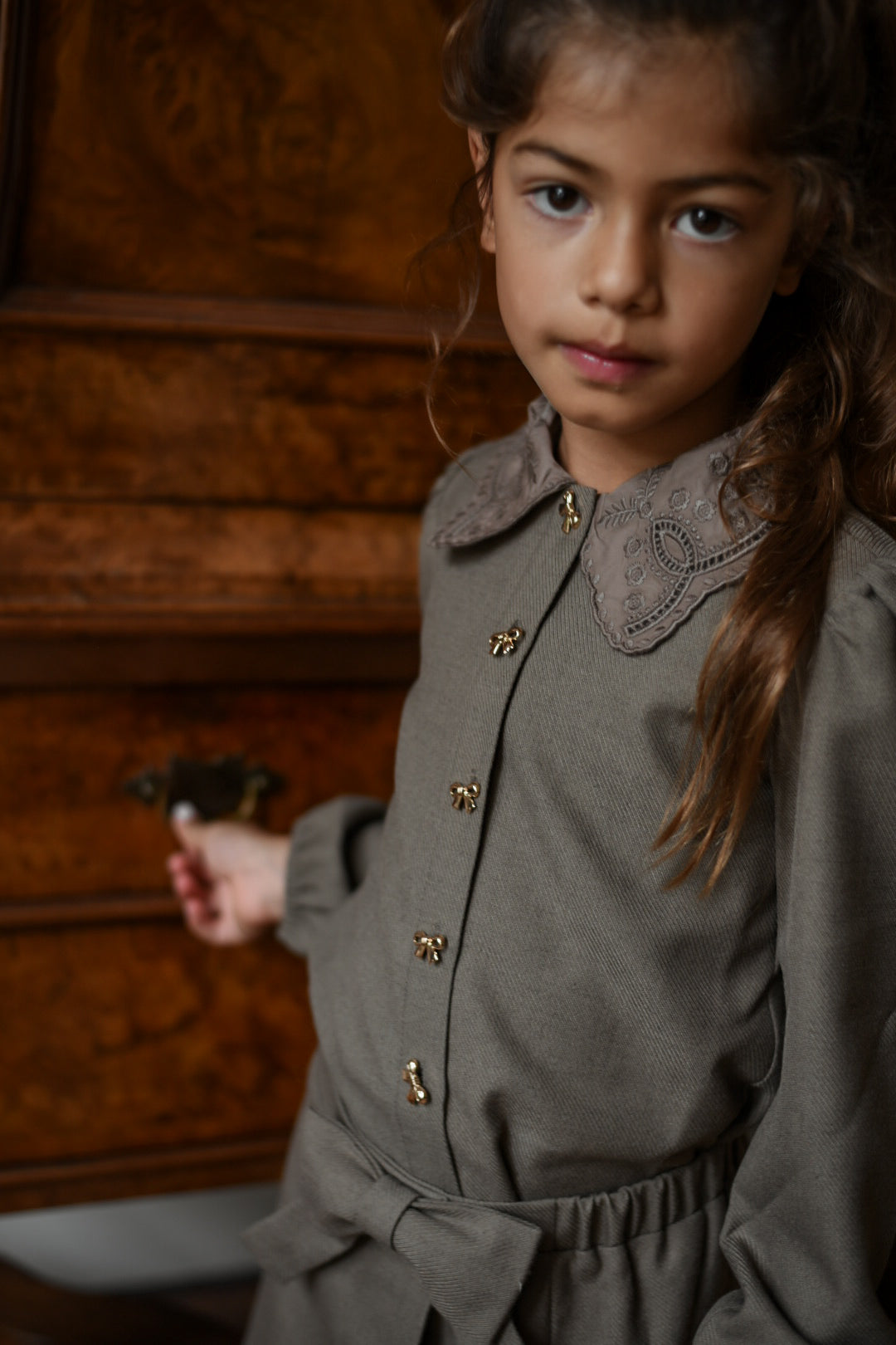 Close-up of the embroidered collar, bow buttons and waist bow of the Elle Set in Chocolate