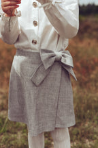 Close-up of the white Valery Blouse and dove Elle Skirt on the heath