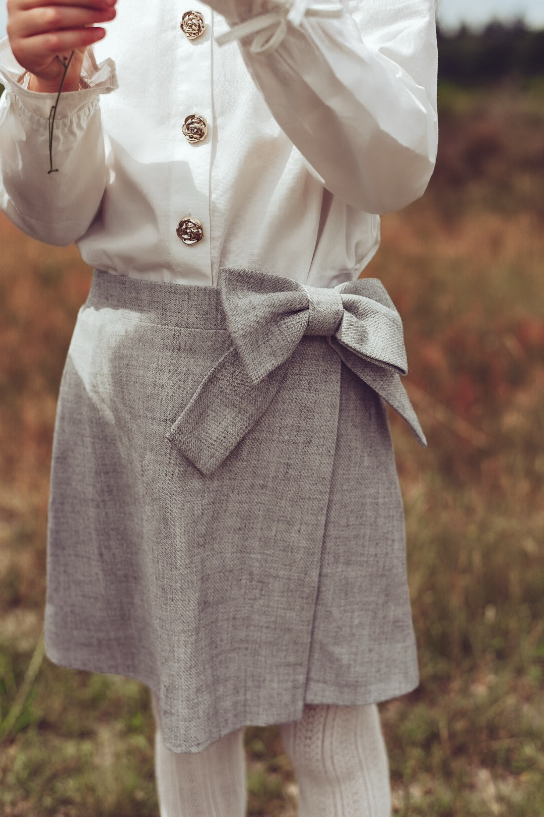 Close-up of the white Valery Blouse and dove Elle Skirt on the heath