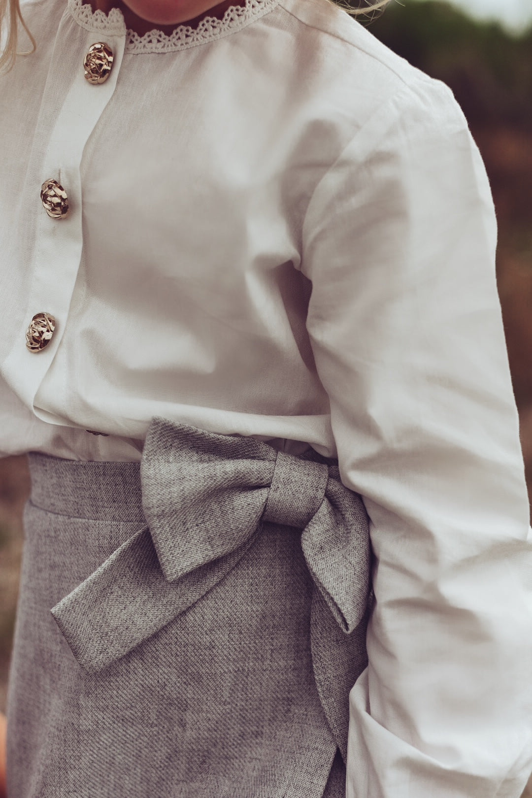Detail of the white Valery Blouse styled with the dove Elle Skirt