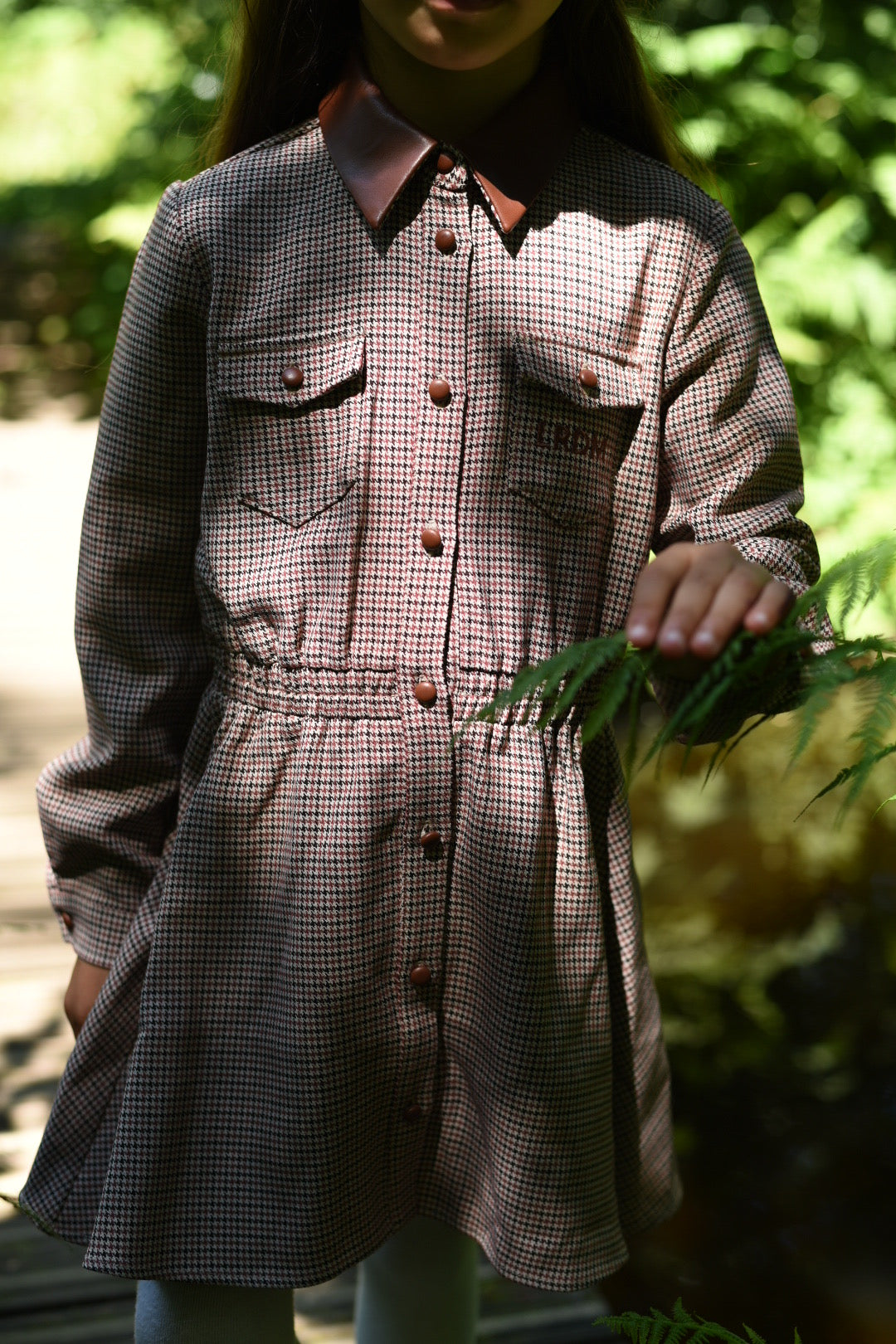 Girl wearing the Isabella Dress in the woodland