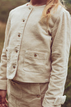 Girl wearing the ivory Louise Jacket with the matching skirt on the heath