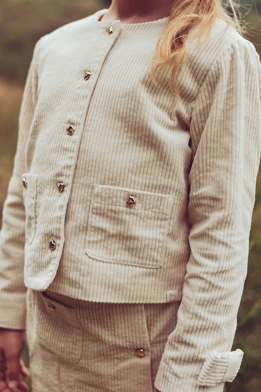 Girl wearing the ivory Louise Jacket with the matching skirt on the heath