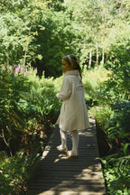 Back view of a girl wearing the Mara Tweed Coat in the woodland