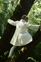 Back view of a girl wearing the Mara Tweed Coat in the woodland