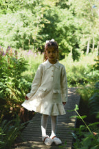 Girl wearing the long-sleeve Mara Tweed Dress in the woodland