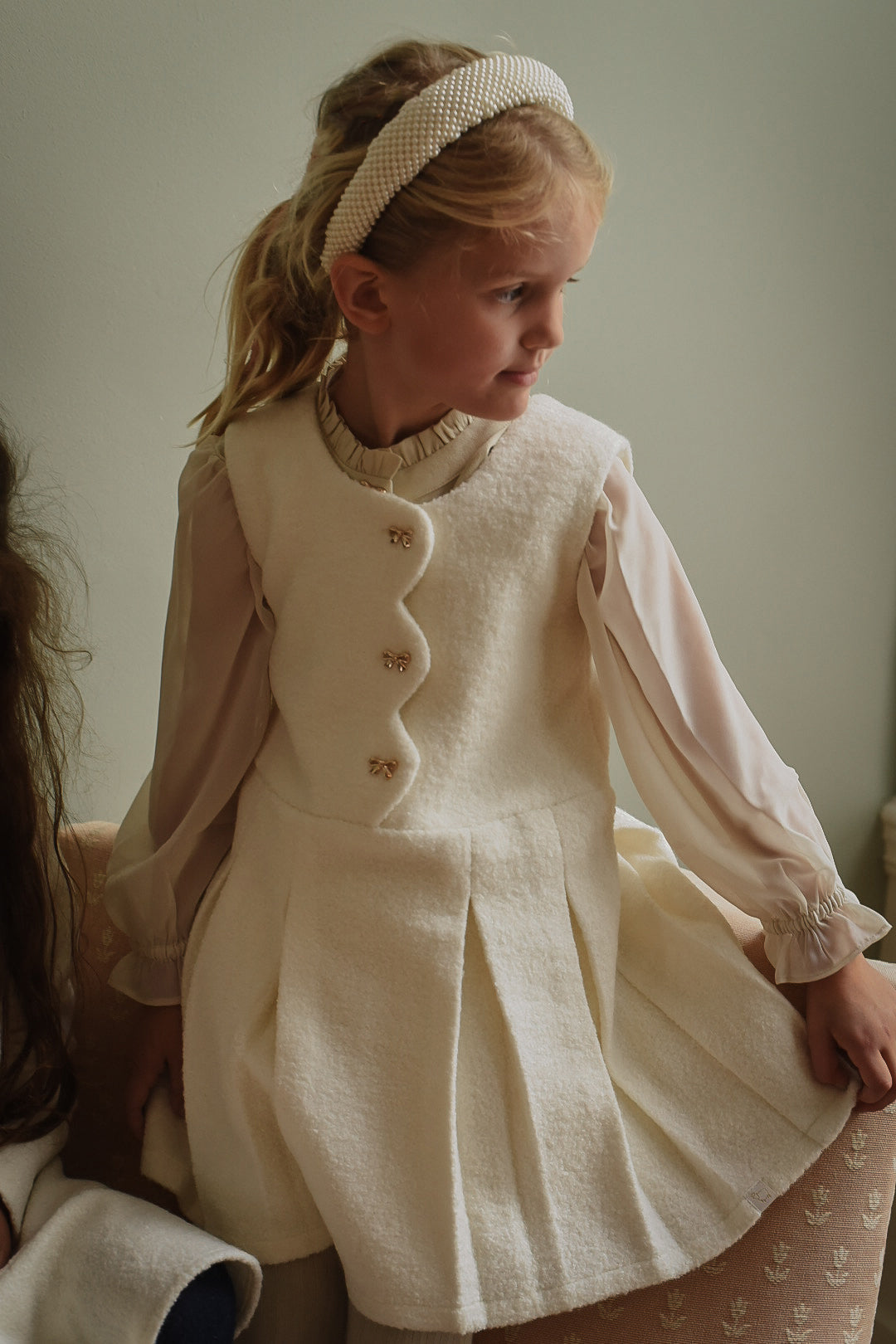 Girl wearing the Mara Tweed Dress in Ivory layered over the Zara Blouse in Sand