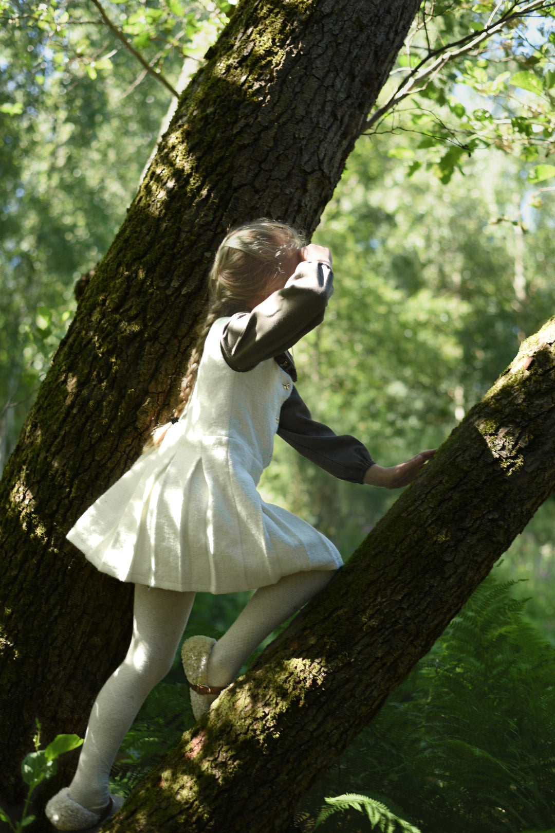 Girl wearing the short-sleeve Mara Tweed Dress in the woodland