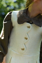 Close-up of ivory Mara Tweed and chocolate Elle details in the woodland
