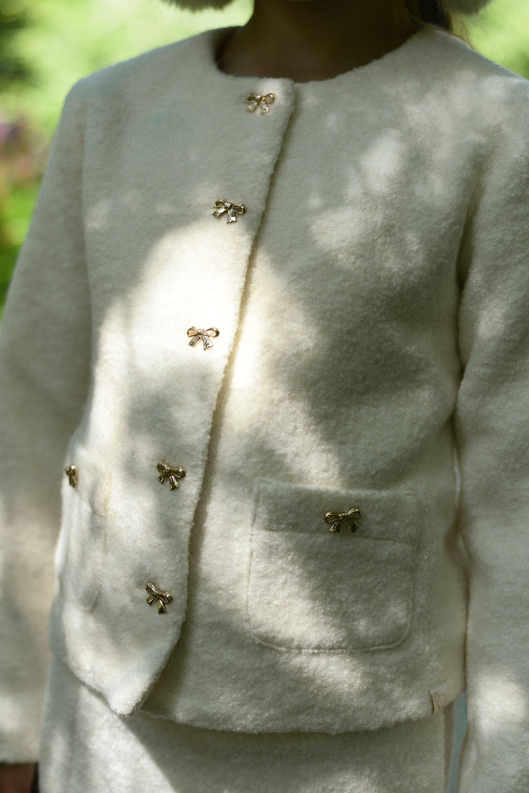Close-up of the Mara Tweed Jacket details in the woodland
