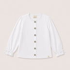 Valery Blouse in White with ruffle collar and gold buttons on a neutral background