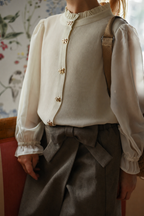 Detail of the Zara Blouse Sand with bow buttons, styled with the Elle Skirt