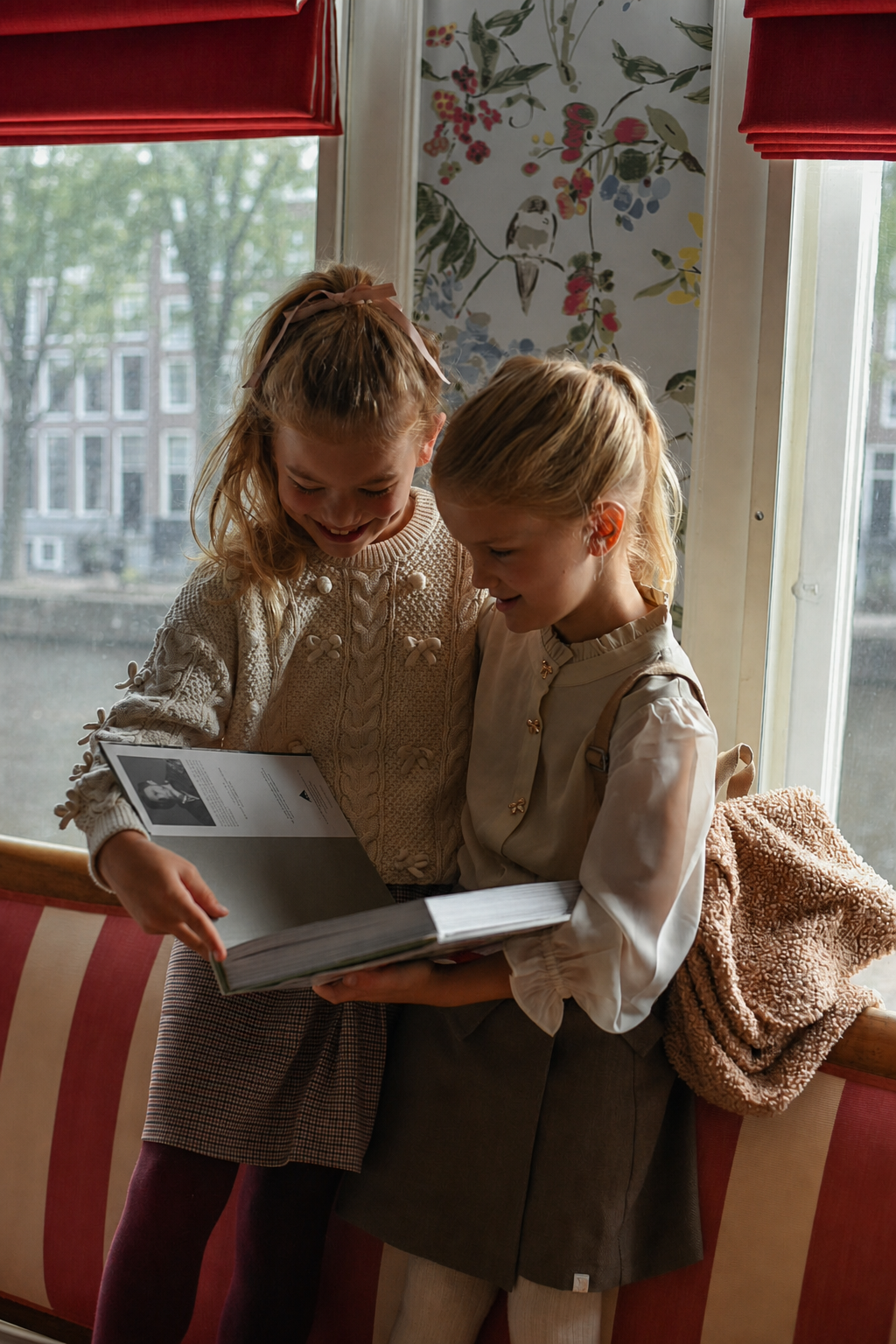 Two girls reading together beside the Canal House windows