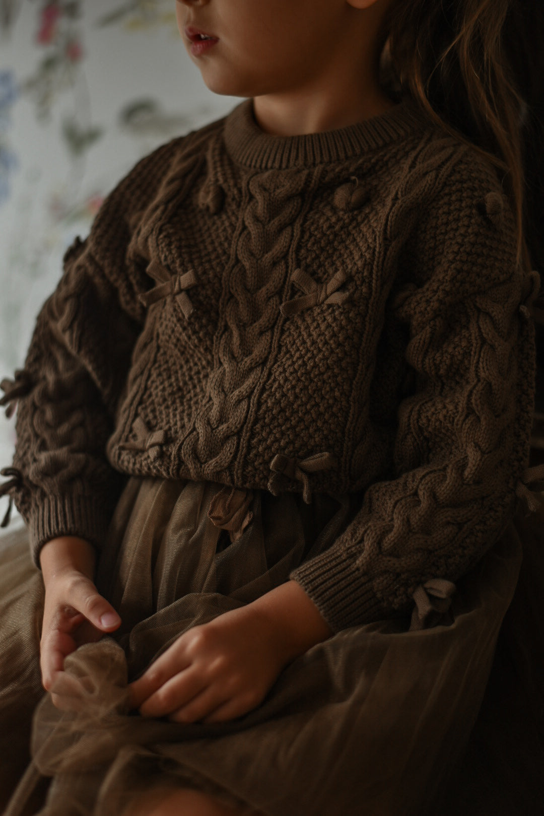 Detail of the cable knit and bow details on the Elise Bow Pull in chocolate