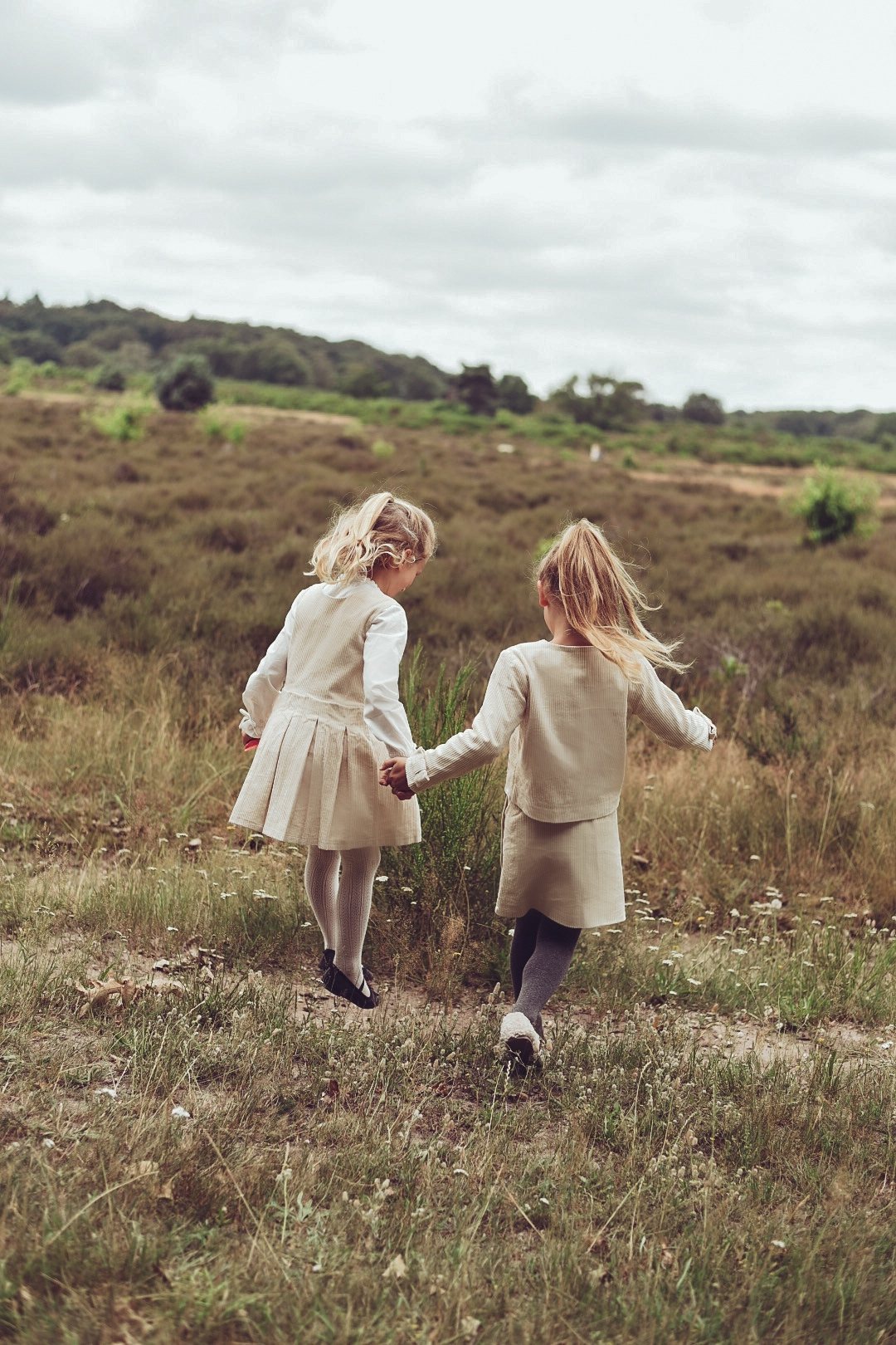 Two girls walking together through the heath in winter white AW26 looks
