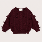 Elise Bow Pull in Burgundy with cable-knit bow details on a warm neutral background