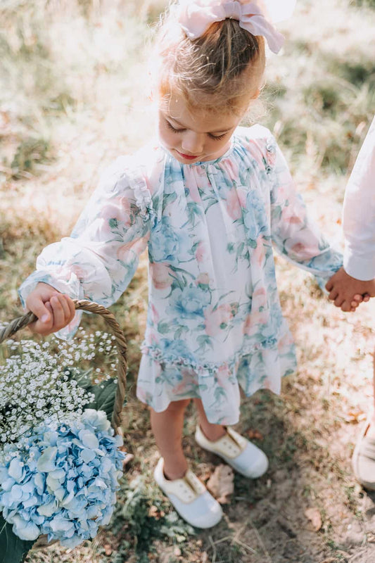 Twirl around in our beautiful chiffon Belle dress. This luxurious and super comfortable dress for girls is a new LRDM petits style. Designed with a perfect fit and ruffle details at the sleeves and skirt that catches the eye. The off white base with gorgeous soft blue and soft pink flowers as also the summer green leaves make this floral print romantic, soft and playful. 