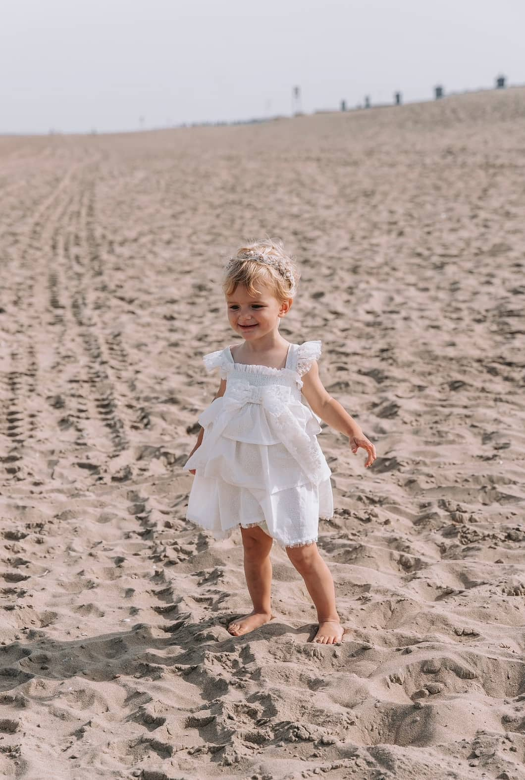 A new eyecatcher by LRDM petits. This white lace dress is designed with a beautiful white floral fabric and a smock top. The skirt consists of 3 different layers, which are finished with the most beautiful white lace details. This dress for girls has lace sleeves on the shoulder, a large lace bow on the front with a playful ruffle above. The Vive dress is comfortable and extremely suitable for special occasions. Comfortable, romantic and luxurious, exactly what LRDM petits stands for.